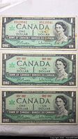Three 1967 Centennial one-dollar Canadian banknotes stacked