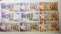 Nine Ghanaian cedi notes laid out, showing both denominations