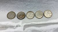 Five Canadian dimes lined up showing reverse side