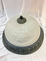 Full view of frosted glass dome ceiling light with aged bronze base and finial