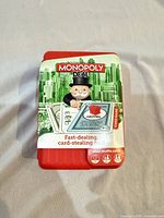 Front of red plastic carrying case with Monopoly Deal branding