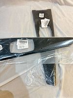 Pair of carbon fiber look trim pieces in bags