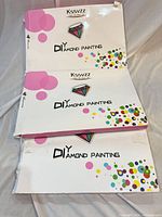 Three Kssvzz DIY Diamond Painting kit boxes stacked, visible edge damage