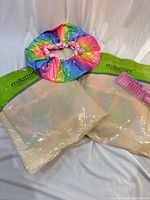 Two sealed mikimini pouches, loose rainbow shower cap and pink comb