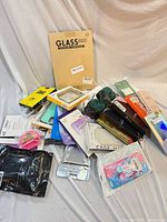 Pile of packaged phone cases, screen-protector pack and ceramic dog figurine