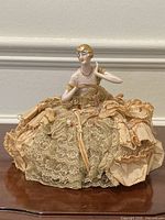 Full view of porcelain half doll pincushion on table