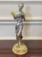 Full front view of pewter girl statue on base