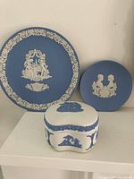 Front view of all three Wedgwood Jasperware items: blue Valentine 1984 plate, blue 1982 Prince William pin dish, white kidney-shaped trinket box
