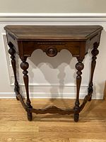 Front view of Edwardian walnut demilune console table showing overall form and condition