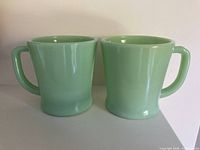 Front view of both jadeite mugs side by side