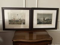 Both framed aquatints side-by-side on table