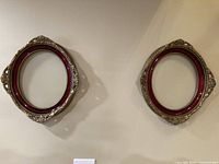 two matching ornate oval frames on wall