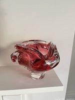 Front view showing cranberry cased glass vase on foot