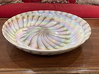 Top angled view of iridescent Laguna nautilus glass bowl on wood surface