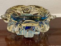Front view of sculptural Murano glass bowl showing clear, amber, blue layers