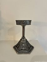 Full view showing entire candlestick with hexagonal base and relief decoration