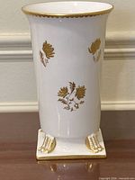 Front view highlighting gold floral decoration and claw feet