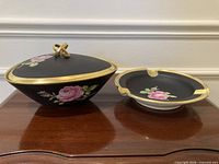 Covered serving bowl and ashtray side by side on table