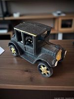 Side view of cast iron coupe car showing body shape and gold wheels