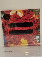 Front view of sealed Ed Sheeran “=” clear vinyl LP showing artwork and hype sticker