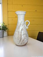 Full view of jug showing overall form, glaze, handle, swirl motif