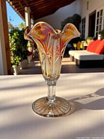 Full view of vase showing pedestal, ruffled rim and iridescent finish