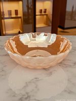 Angled top view of peach lustre bubble bowl on marble surface
