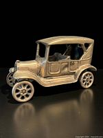 three-quarter front view of brass Model T style car