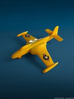 Left front perspective of yellow Marx Banshee toy jet on blue backdrop