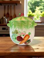 front view of ceramic cookie jar displaying fruit and vegetable design