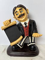 Front view of resin waiter figurine holding chalkboard menu board