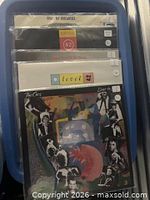 Stack of five vinyl records in plastic sleeves showing spine titles