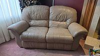 Front view of tan leather reclining loveseat