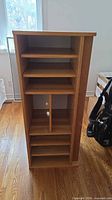 Front view of light brown oak veneer bookshelf with open shelves and divider