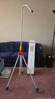 Full view of assembled tripod outdoor shower with box behind couch