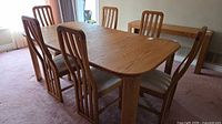 Oak dining table with six chairs viewed from side