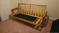 overall view of wooden futon frame with mattress