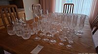 Full grouping of assorted crystal and glass barware on table