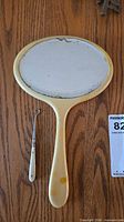 Front of cream celluloid hand mirror with button hook