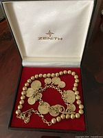 Open Zenith box displaying both jewelry pieces on red velour