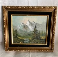 Front view of framed oil painting showing mountain scene and ornate gold/black frame