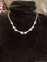 Necklace displayed on black stand, front view