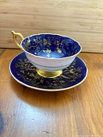 Teacup on saucer showing cobalt blue and gold design