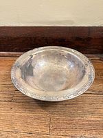 top view of tarnished metal bowl showing floral rim and interior