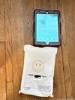 Front view of tablet case on device and sealed packaging