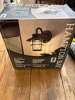 Front of box displaying Hampton Bay outdoor wall lantern