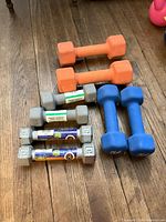 All eight dumbbells arranged by pair on wood floor