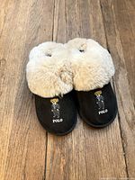 Top view of slippers showing black exterior, faux-fur cuff, Polo bear embroidery