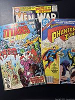Group shot of three DC Comics issues: The New Teen Titans #15, All-American Men of War #110, The Phantom Zone #3.