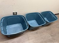 Three teal storage bins side-by-side showing interior and color